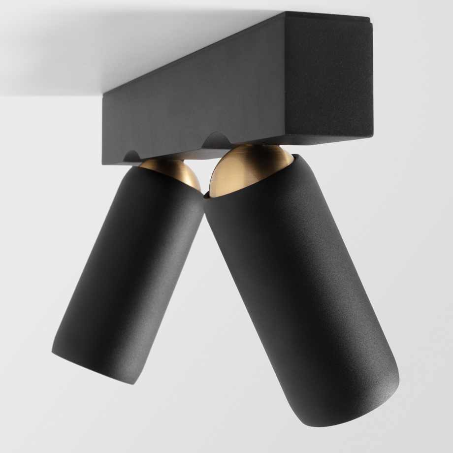 Black surface-mounted spotlight with a golden touch