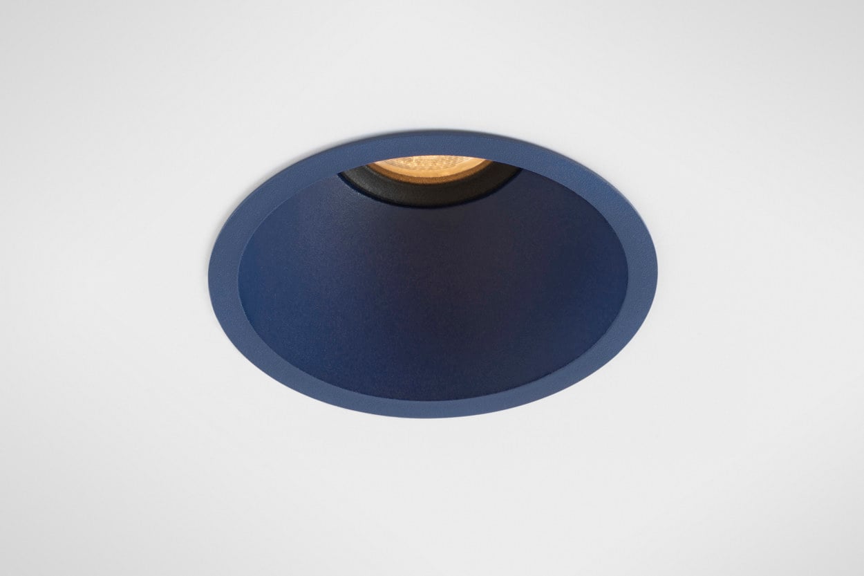 Front-facing close-up of Klevr recessed spotlight in custom Deep Blue finish. The smooth conical shape recedes seamlessly into the ceiling, drawing the eye towards the deeply recessed light source. The coloured interior adds depth and character, while the precision optics ensure comfortable, glare-free illumination.