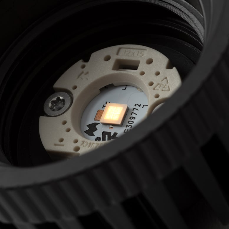 Extreme close-up of Kup’s LED module and optical core, revealing the precision-engineered components hidden within the spotlight. The illuminated LED chip sits at the centre of the assembly, surrounded by carefully designed elements that ensure efficient light control, high performance and long-lasting reliability.