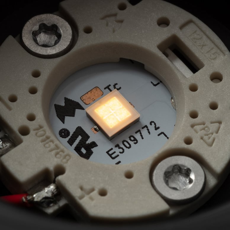 Extreme close-up of Klevr's LED module and optical core, revealing the precision-engineered components hidden within the spotlight. The illuminated LED chip sits at the centre of the assembly, surrounded by carefully designed elements that ensure efficient light control, high performance and long-lasting reliability.